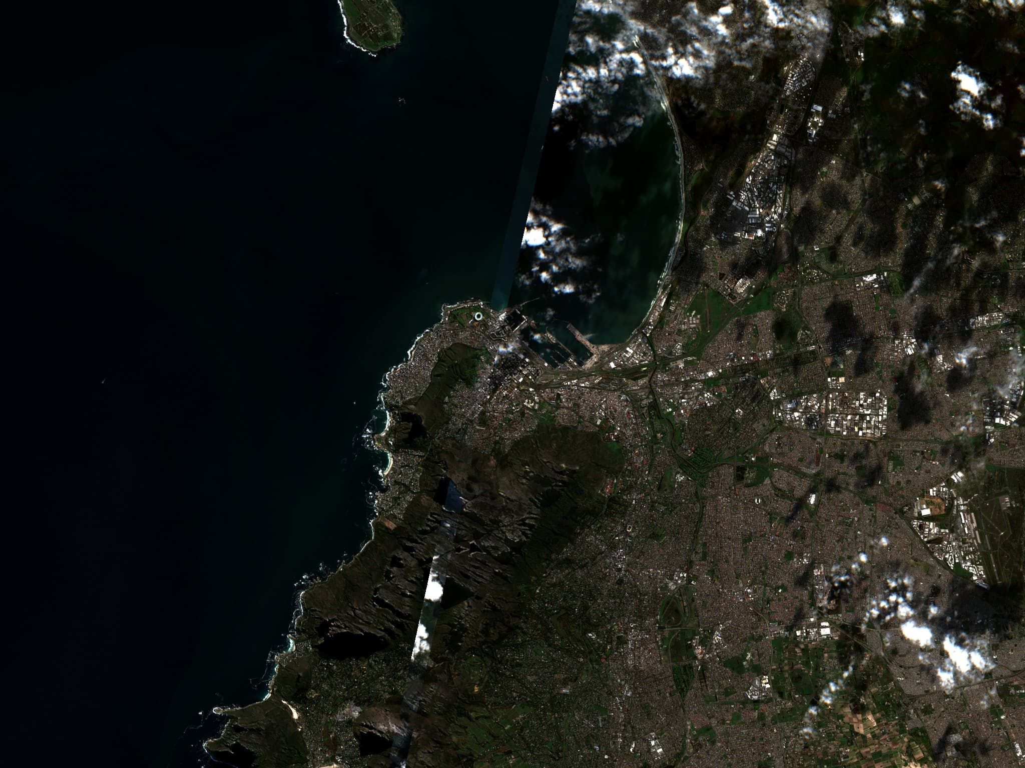 Satellite view of a rugged coastline meeting blue water
