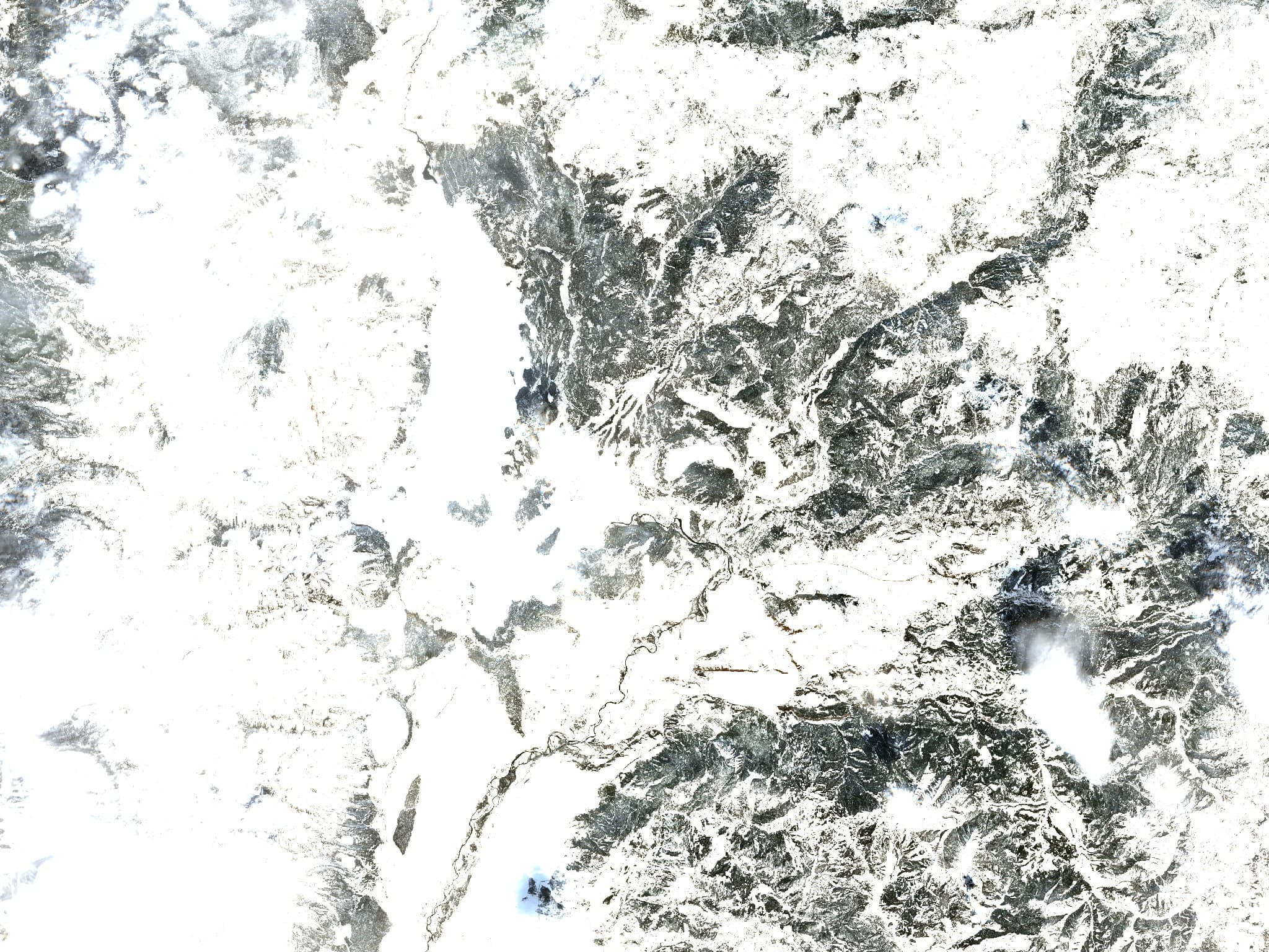 Satellite view of mountain ridges, valleys, and snow